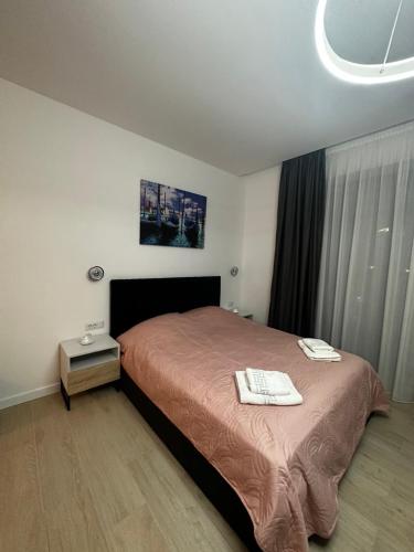 a bedroom with a bed and a table with towels on it at Studio Ale LakeOn in Mamaia