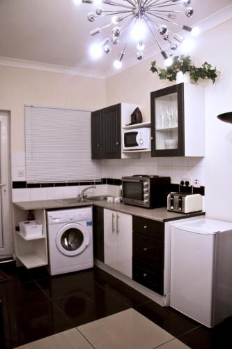 cocina con lavadora y microondas en *NEW* Chic Guest Suite - Nr Wembley stadium en Londres