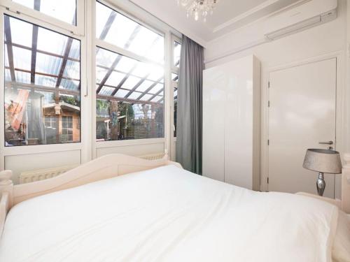 ein Schlafzimmer mit einem weißen Bett und einem Fenster in der Unterkunft Hosted by Wendy with garden in Den Haag