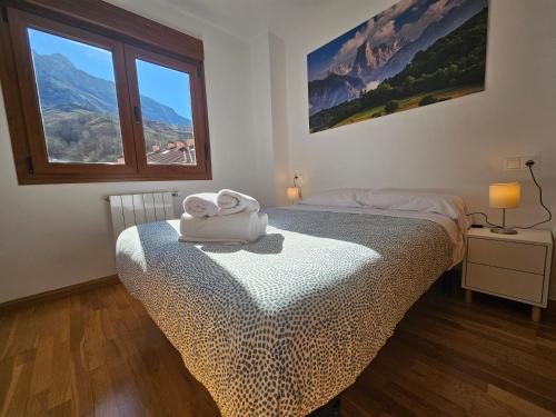 a bedroom with a bed with a towel on it at 24A03 Apartamento en plena naturaleza en Arenas de Cabrales in Arenas de Cabrales