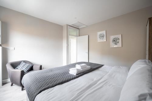 a white bedroom with a bed and a chair at Kennington Apartment D/Apartment in London