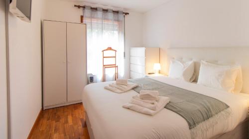 um quarto com uma grande cama branca com toalhas em Fabulous Matosinhos Apartment by Unique Hosts em Senhora da Hora