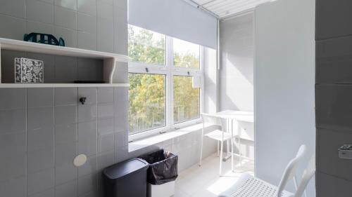 Fabulous Matosinhos Apartment by Unique Hosts في Senhora da Hora: حمام أبيض مع حوض استحمام ونافذة