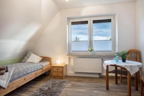 a bedroom with a bed and a window and a table at Haus Heidorn in Sittensen