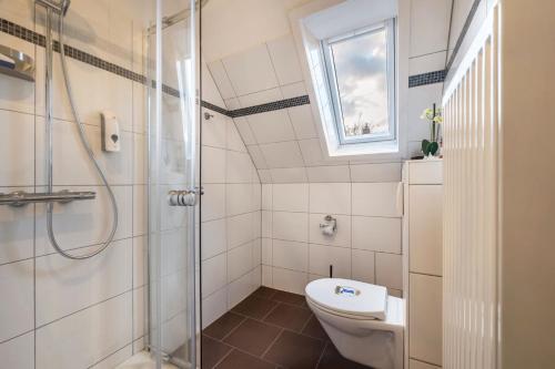 a bathroom with a toilet and a shower and a window at Haus Heidorn in Sittensen