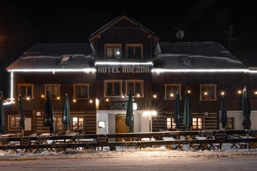 a hotel hogar with snow in front of a building at Hotel Hvezda in Pec pod Sněžkou