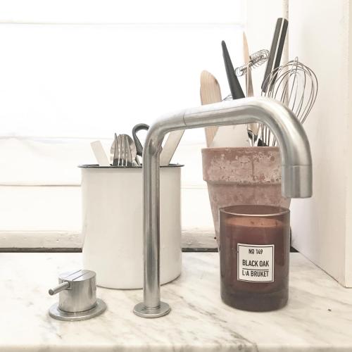 a kitchen sink with a faucet and a candle at The architects' house in Stockholm