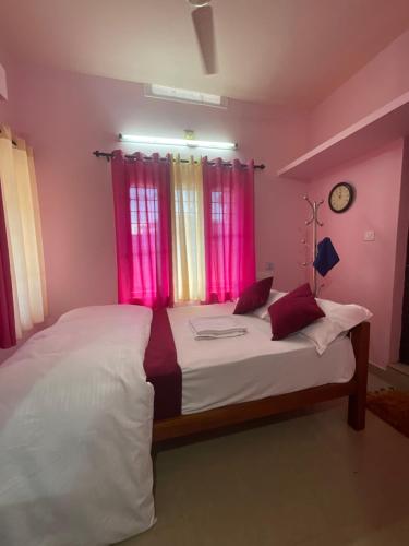 een slaapkamer met 2 bedden en roze gordijnen bij anliyaholidayhome in Anachal