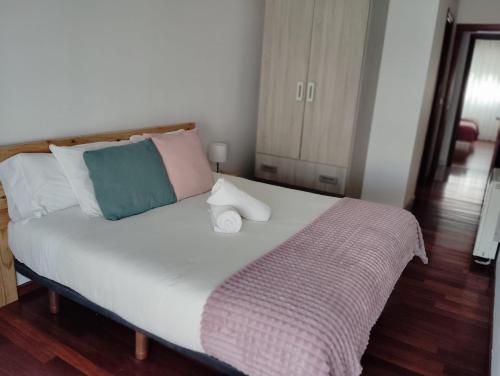 a bedroom with a large white bed with colorful pillows at El rincón de Leny in Cangas de Morrazo