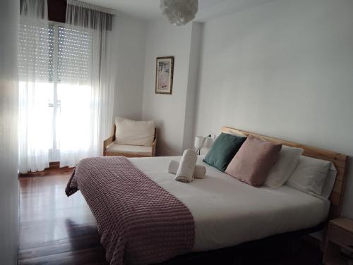 um quarto com uma cama grande e almofadas em El rincón de Leny em Cangas de Morrazo
