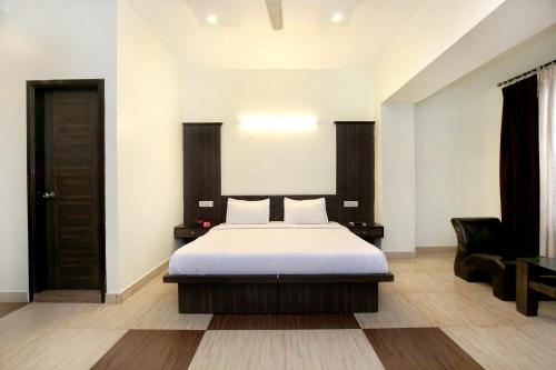 a bedroom with a bed and a chair at OYO 9243 Trumpets Hotel in Amritsar