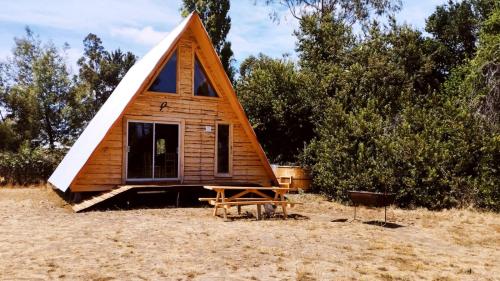 una casa pequeña con techo triangular en Travesía Rukamanque Lodge, en Temuco
