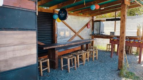 una mesa de picnic y algunos taburetes bajo un edificio en Travesía Rukamanque Lodge, en Temuco