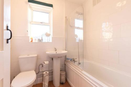 uma casa de banho branca com um WC e um lavatório em Bluebell House em Southampton