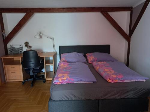 Schlafzimmer mit einem Bett, einem Schreibtisch und einem Stuhl in der Unterkunft Ferienwohnung am Weißgerbermuseum in Doberlug-Kirchhain
