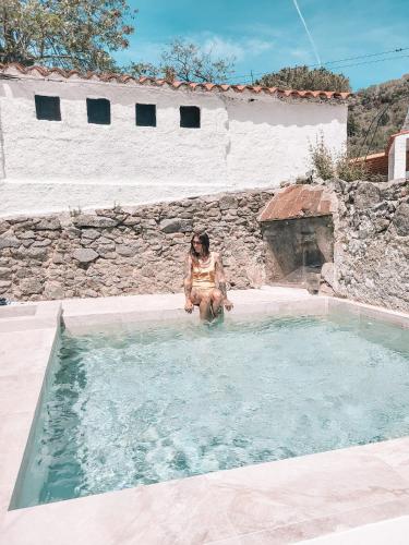 Una donna è seduta in una piscina di Casa Om a Dosríus