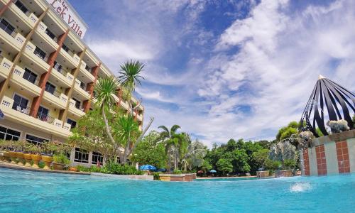 a large swimming pool in front of a hotel at Lek Villa in North Pattaya