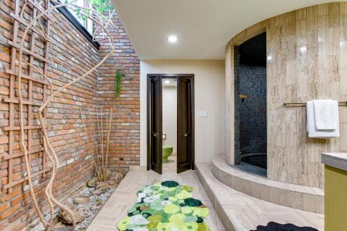 La salle de bains est pourvue d'un mur en briques. dans l'établissement Unique Luxury Apartment 7 Mi to Downtown Denver!, à Wheat Ridge