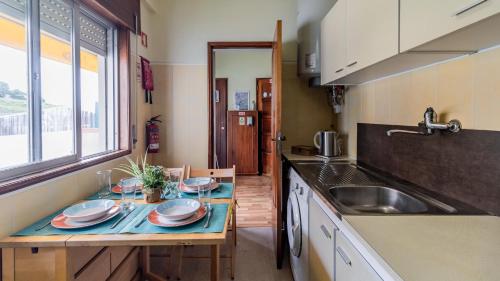 eine kleine Küche mit einem Tisch und einem Waschbecken in der Unterkunft Cute MonteCativo Apartment by Unique Hosts in Porto