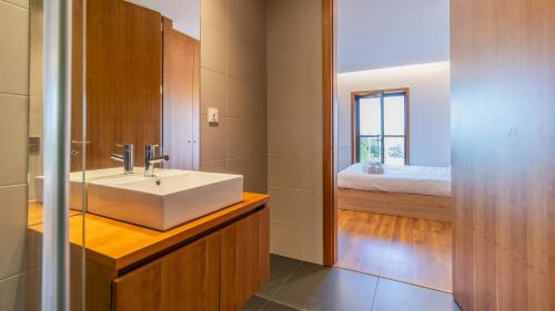 een badkamer met een witte wastafel en een slaapkamer bij Cute Asprela Apartment by Unique Hosts in Porto