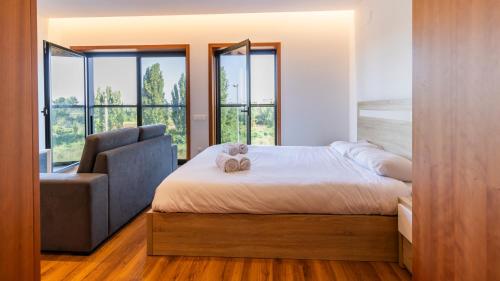 een slaapkamer met een bed, een stoel en ramen bij Cute Asprela Apartment by Unique Hosts in Porto