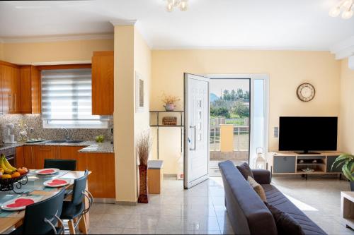 een keuken en woonkamer met een bank en een tafel bij Katerina Apartment in Afantou