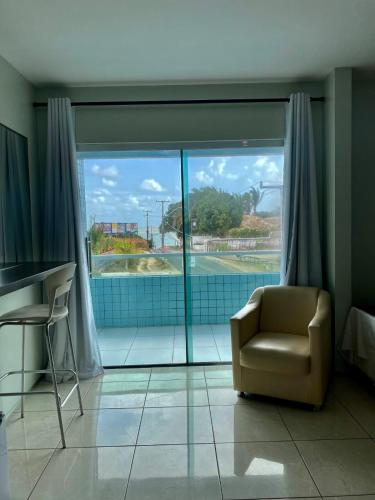 a living room with a chair and a window at Hotel Adventure São Luís in São Luís