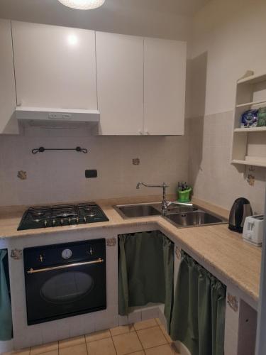 a small kitchen with a stove and a sink at Marica's Apartment in Gallinaro