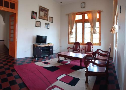 a living room with a table and chairs and a window at PONDOK SITI RAWIYAH Guest House in Bukittinggi