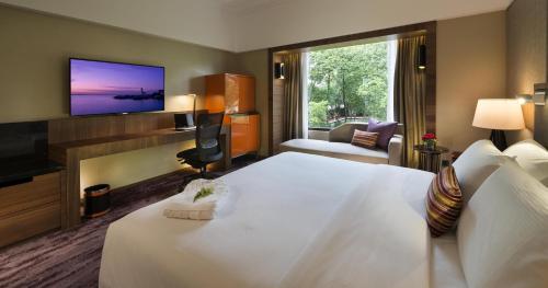 a hotel room with a large bed and a television at The Saujana Kuala Lumpur in Subang Jaya