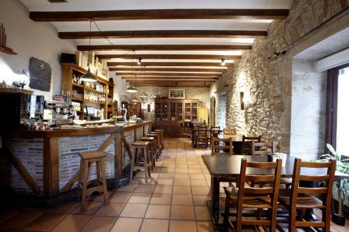 a restaurant with a bar and tables and chairs at Hotel Convento San Roque in Balmaseda