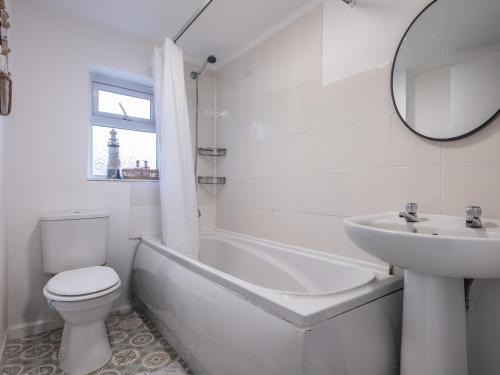 a white bathroom with a toilet and a sink at Cosy Coastal Apartment in Whitley Bay