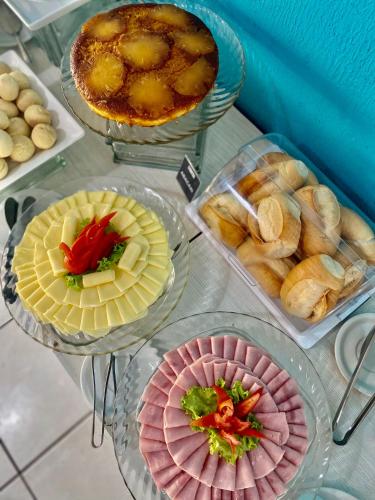 a table topped with different types of food on plates at Hotel Adventure São Luís in São Luís