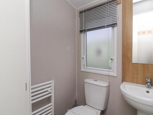 a bathroom with a toilet and a sink and a window at The Moon in Morecambe