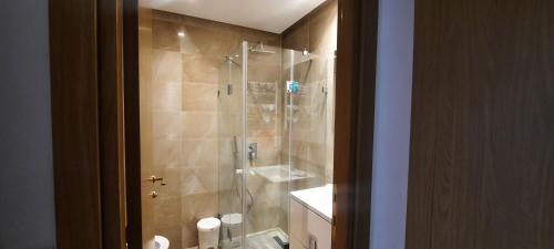 baño con ducha y puerta de cristal en One bedroom appartement, en Túnez