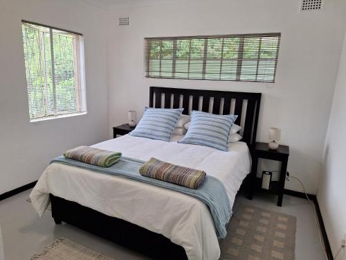 a bedroom with a large bed with two pillows on it at Siesta Cottage in Howick