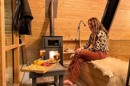 a woman sitting on a bed with a tray of food at OUTSCAPE l Cabaña Familiar en mejor sector de Cerro Castillo in Villa Cerro Castillo