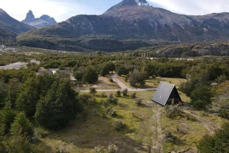 a small house in a field with mountains in the background at OUTSCAPE l Cabaña Familiar en mejor sector de Cerro Castillo in Villa Cerro Castillo
