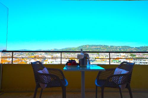 une table avec deux chaises et une table avec vue dans l'établissement Studio Cannes Grand Hôtel Ibis avec Terrasse, à Cannes