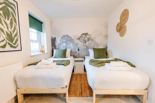 2 łóżka pojedyncze w pokoju z oknem w obiekcie Home in Barrow w mieście Clitheroe