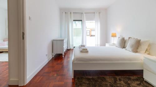 a white bedroom with a white bed and a window at Fabulous Boavista Apartment by Unique Hosts in Porto