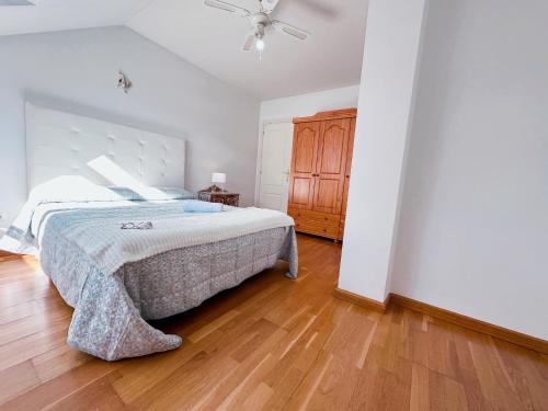 a bedroom with a bed and a ceiling fan at Alianza del Castillo in Ponferrada