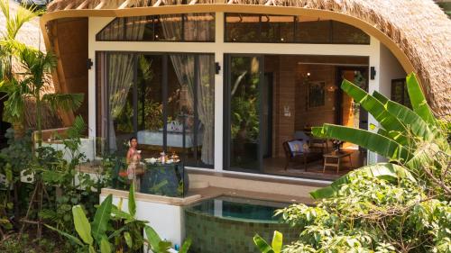 a house with a swimming pool in a garden at Three Monkeys Villas in Patong Beach