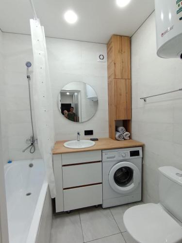 a bathroom with a sink and a washing machine at 2-х комнатная квартира Гоголя 106 in Semey