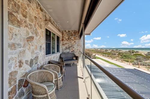 a balcony with chairs and a view of the ocean at Sandpiper Retreat - Breathtaking Beachfront Panorama in Adelaide
