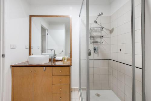 y baño con lavabo y ducha. en 'Flinders Lane Flair' Compact City-centre Comforts, en Melbourne