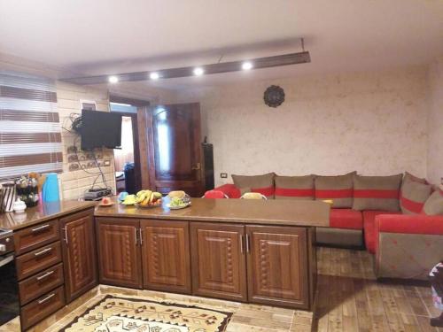 een woonkamer met een rode bank en een tafel bij Rural house البيت الريفي in Ajloun