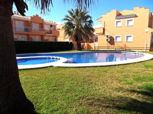 a swimming pool in a yard next to some buildings at Adosado MAR DE CORAL en el Vergel in El Verger