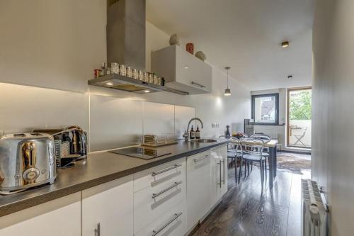 eine Küche mit weißen Schränken und einer Arbeitsplatte in der Unterkunft Le Pura Vida, Hyper centre Terrasse + Parking in Annecy