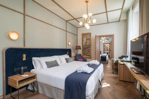 a hotel room with a large bed and a television at Canfranc Estación, a Royal Hideaway Hotel - Gran Lujo in Canfranc-Estación